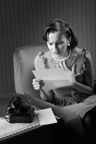 Young woman reading a letter with worried expression